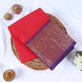 Venkatagiri cotton saree with purple and gold zari border in vibrant dark pink neatly folded top view.