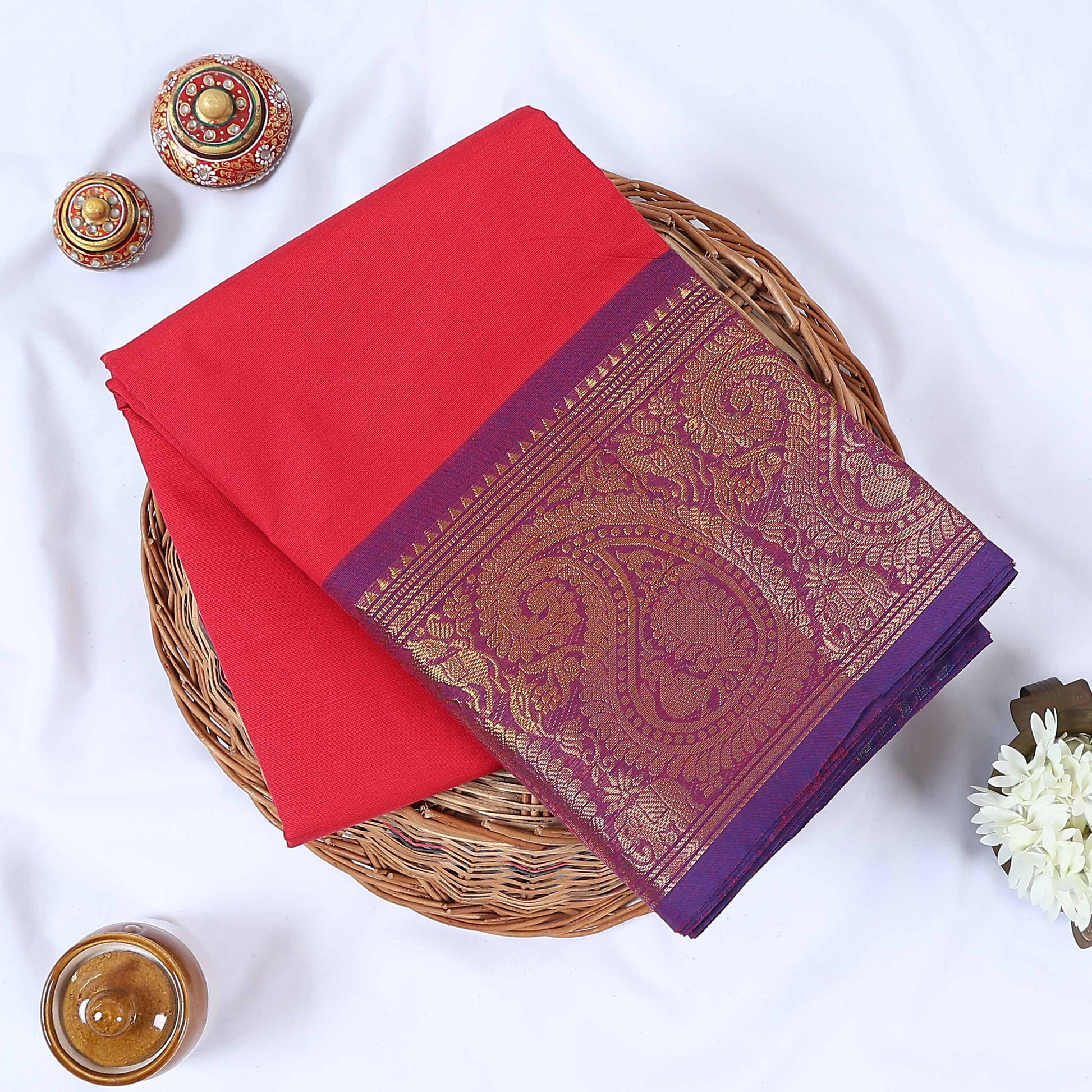 Venkatagiri cotton saree with purple and gold zari border in vibrant dark pink neatly folded top view.