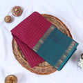 Venkatagiri cotton saree with gold zari checked body and contrast teal zari border in pink neatly folded top view