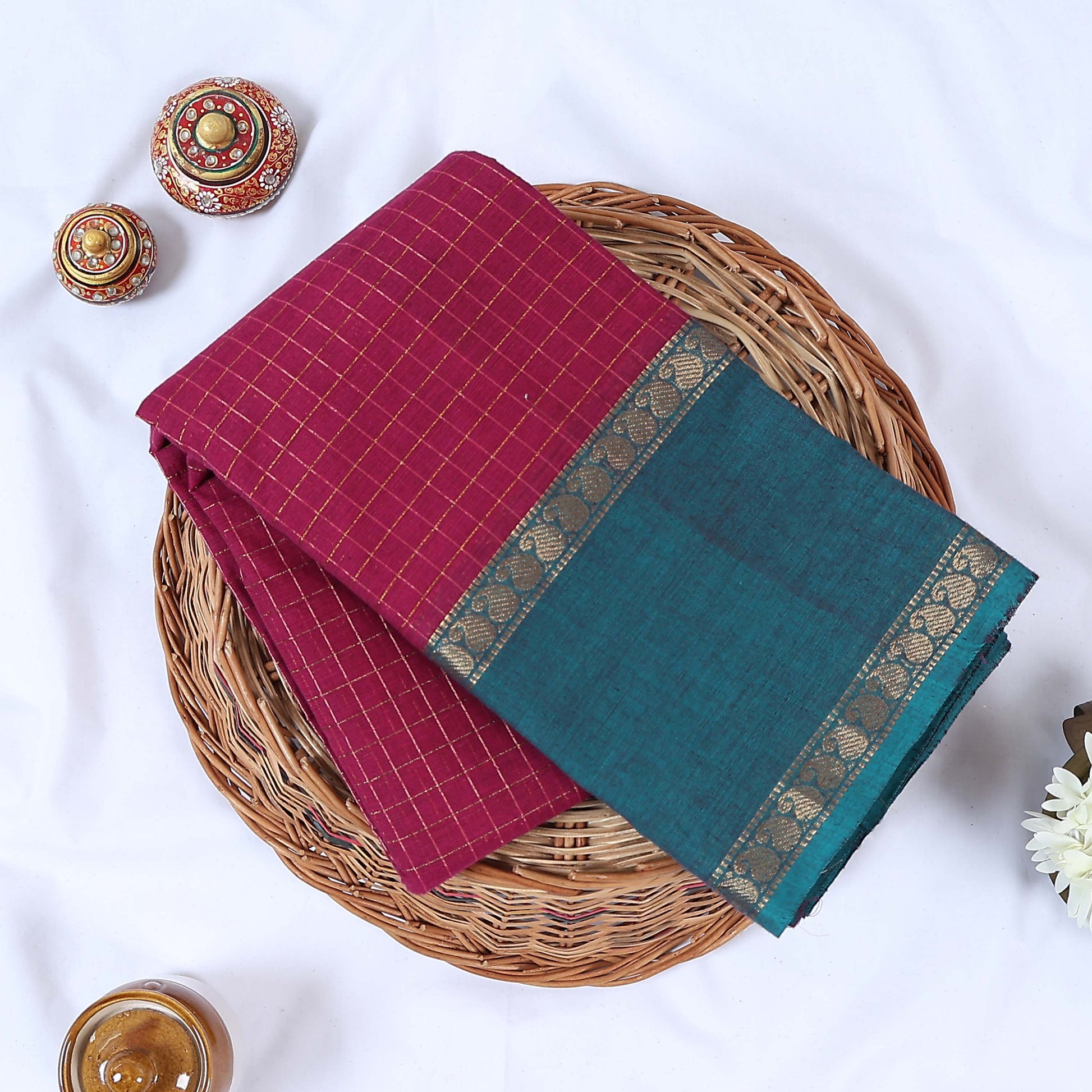 Venkatagiri cotton saree with gold zari checked body and contrast teal zari border in pink neatly folded top view