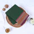 Dark green Venkatagiri cotton saree with purple and gold zari woven border folded flat lay front view.