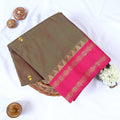 Venkatagiri cotton saree with green body pink temple geometric zari border and floral buttas folded front view.