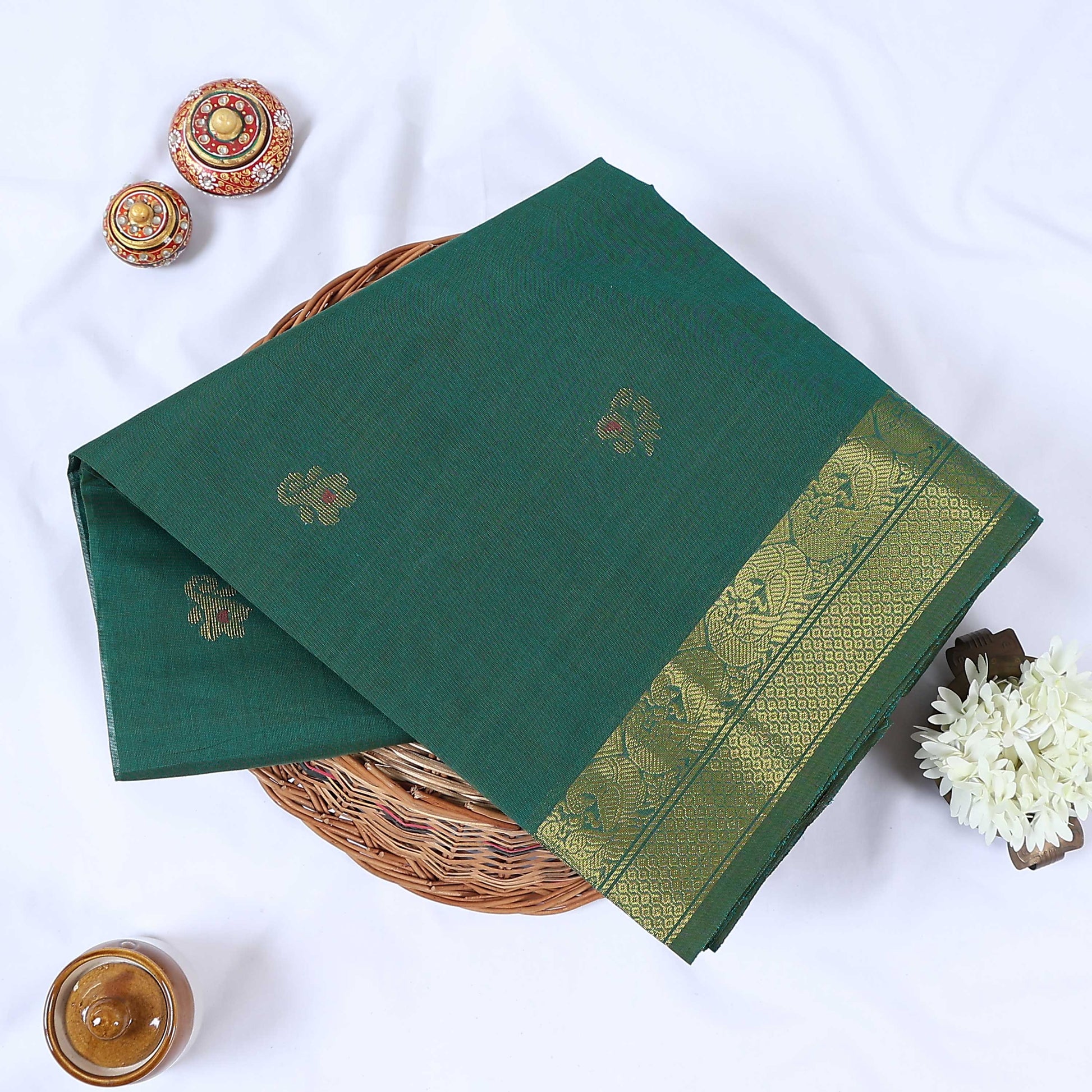 Venkatagiri cotton saree with dark green body peacock zari border and woven floral buttas folded front view.