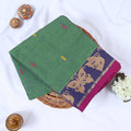 Venkatagiri cotton saree with green body multicolor butta motifs and contrasting floral woven border folded flat lay view.
