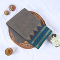 Venkatagiri cotton saree with elegant grey body and teal blue zari border flat lay front view