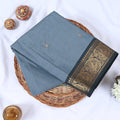 Venkatagiri cotton saree with small zari buttas grey body and dark grey paisley zari border folded top view.
