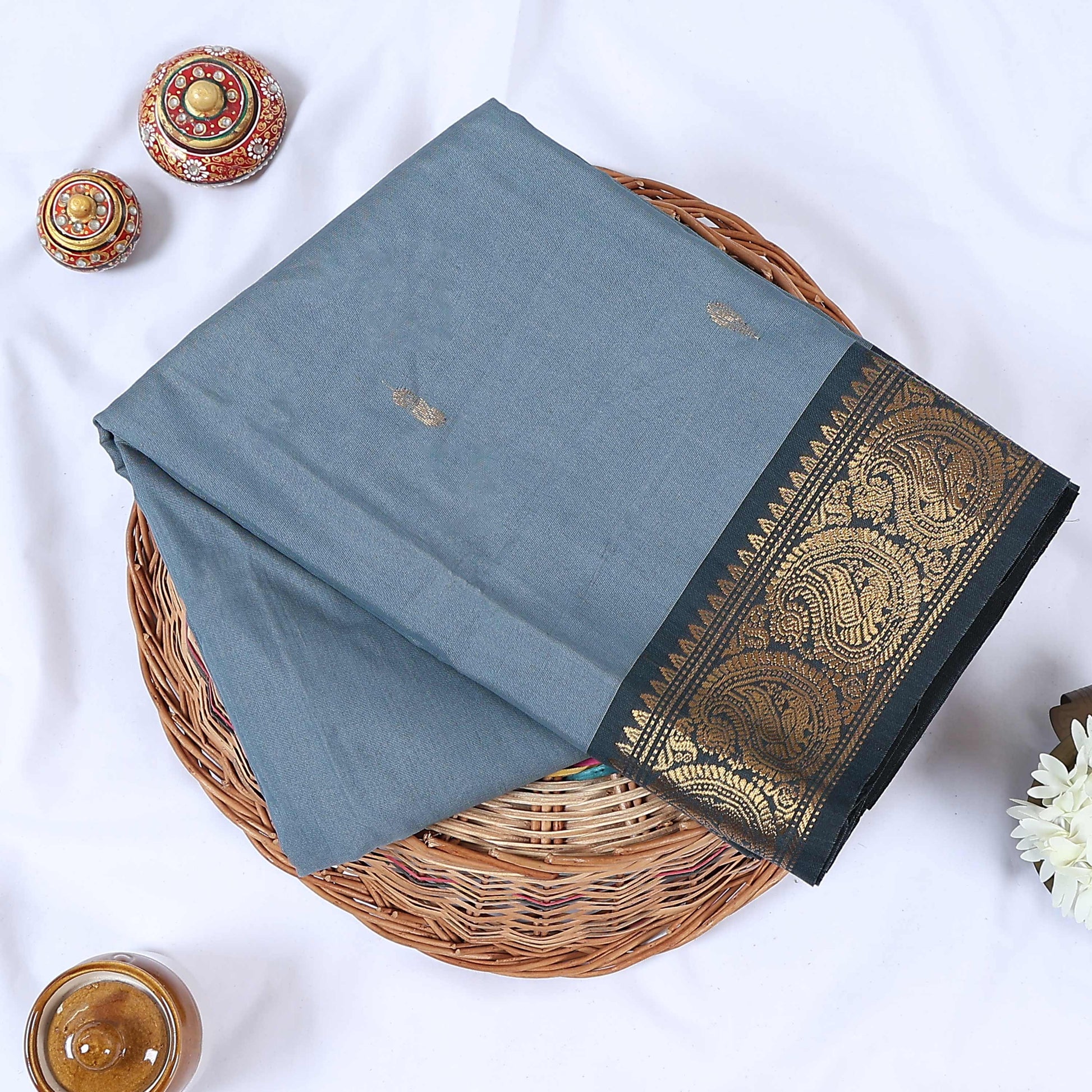 Venkatagiri cotton saree with small zari buttas grey body and dark grey paisley zari border folded top view.