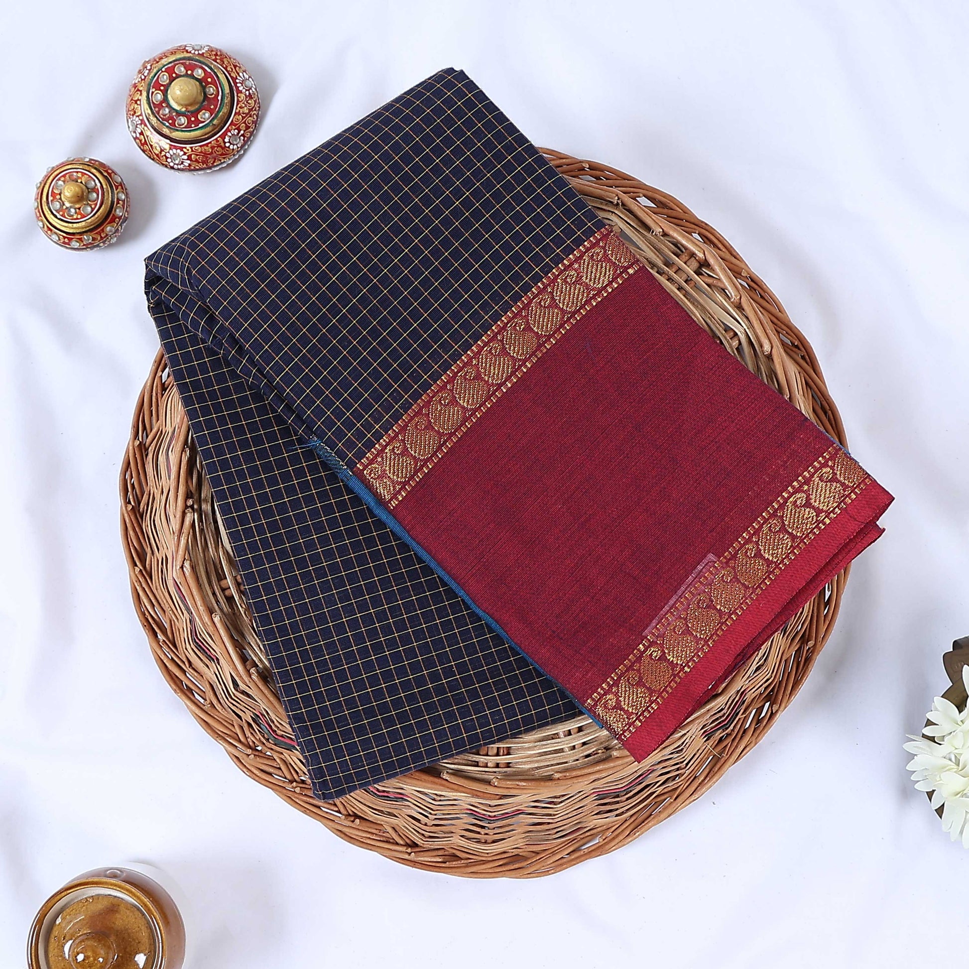 Top view of navy blue Venkatagiri cotton saree with checks maroon contrast border and gold zari motifs.