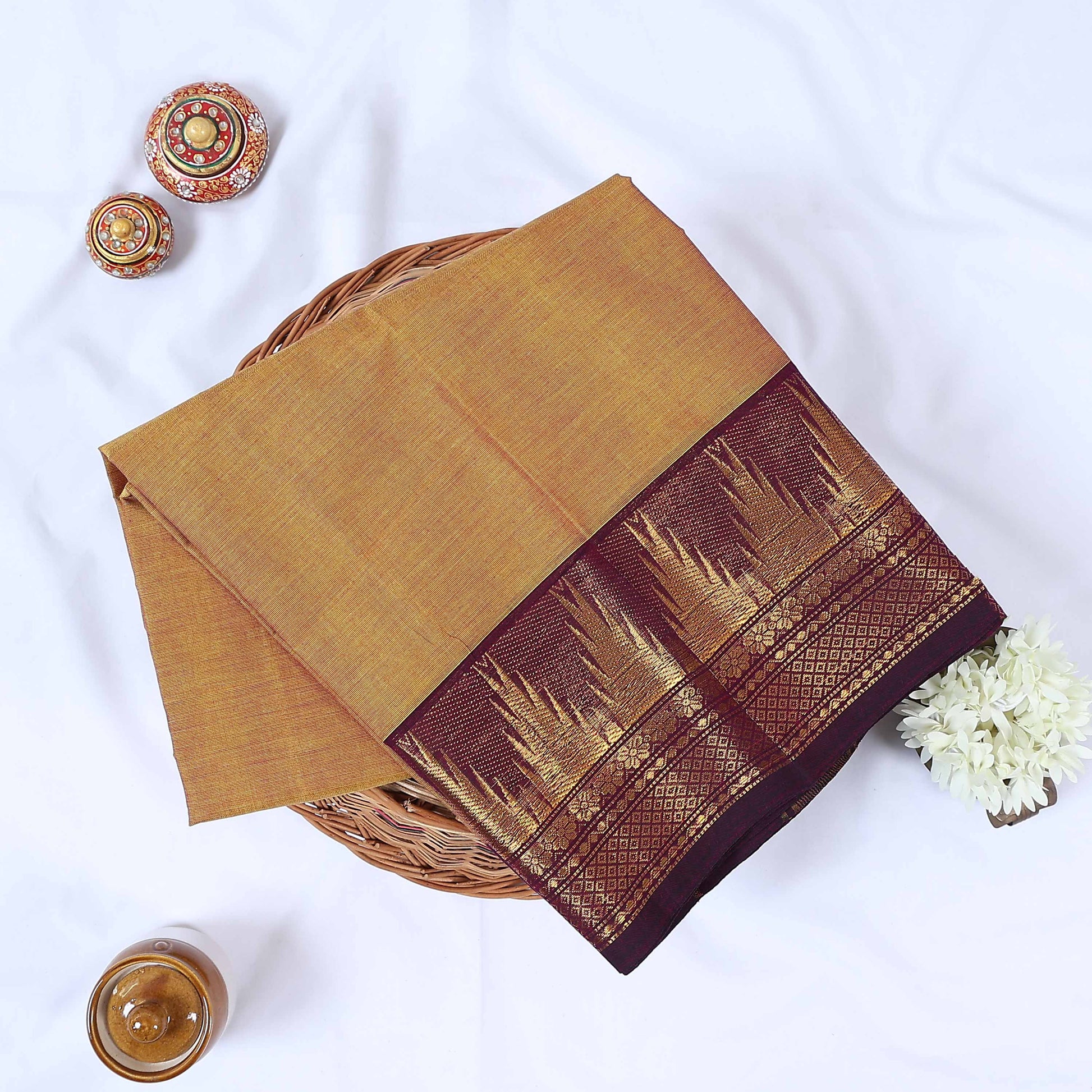 Venkatagiri cotton saree with elegant orange body and pink zari border folded flat lay top view