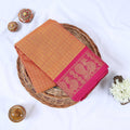 Venkatagiri cotton saree with orange checked body and pink zari border flat lay front view