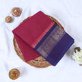Venkatagiri cotton saree with pink body blue peacock zari border folded front view on wicker basket