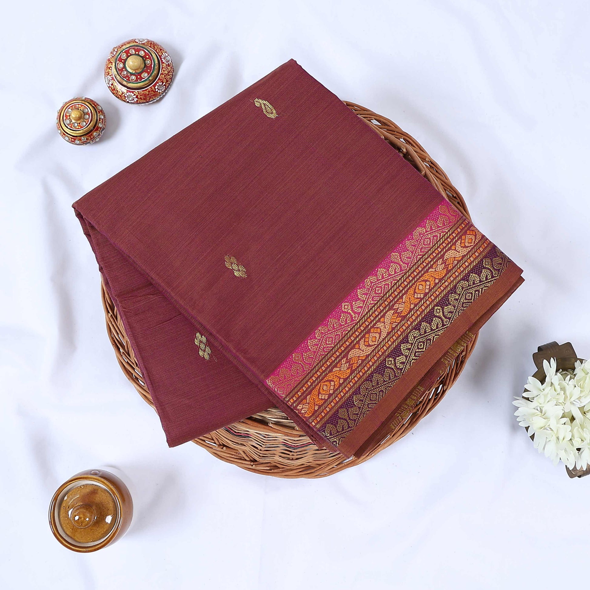 Venkatagiri cotton saree with maroon body gold buttas and pink zari border folded top view