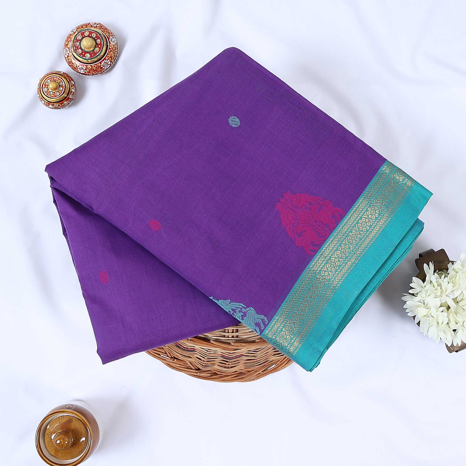 Venkatagiri cotton saree with elegant purple body turquoise zari border and woven motifs folded front view.