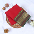 Venkatagiri cotton saree with red body olive green peacock zari border folded front view on wicker basket