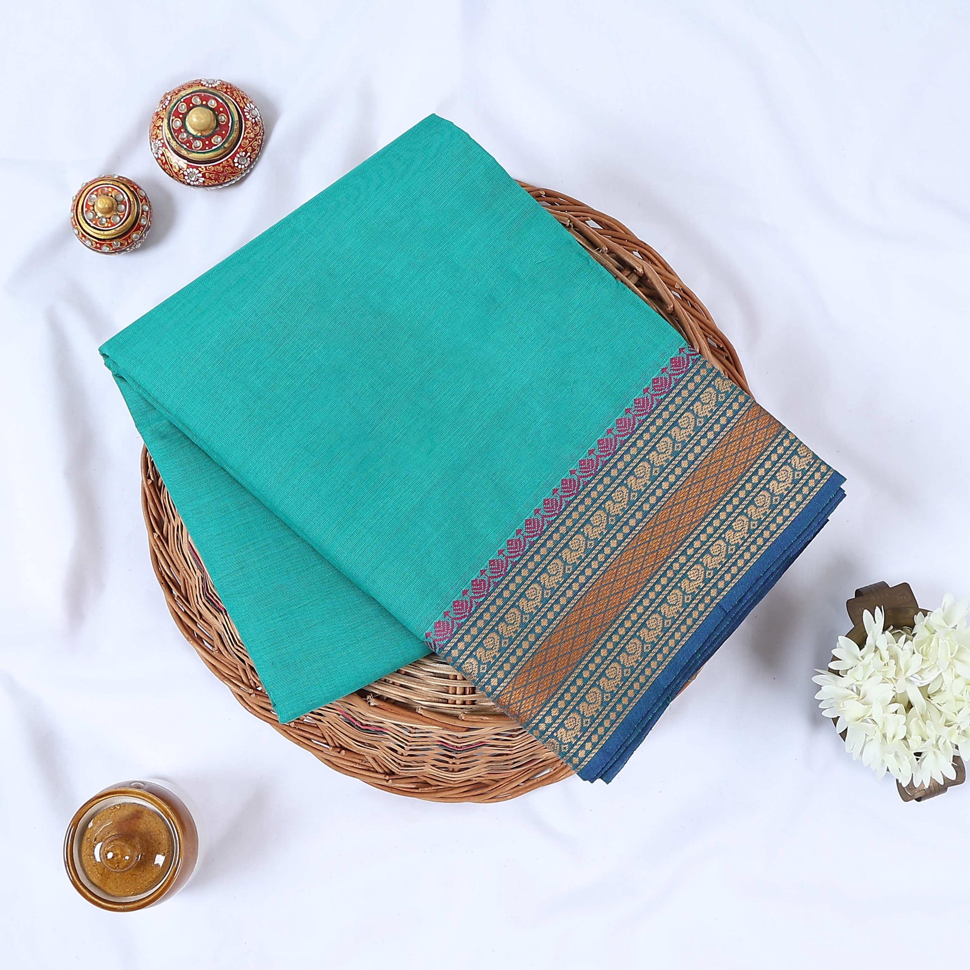 Teal Venkatagiri cotton saree with purple and gold zari woven border folded flat lay front view.