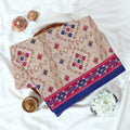 Voile cotton saree with beige geometric motifs and blue pink Ikat border folded display top view