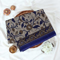 Blue Voile cotton saree with floral vine print and contrast border neatly folded in a top view product display.