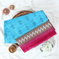 Blue voile cotton saree with ikat printed pattern and contrast chevron zari border folded top view display