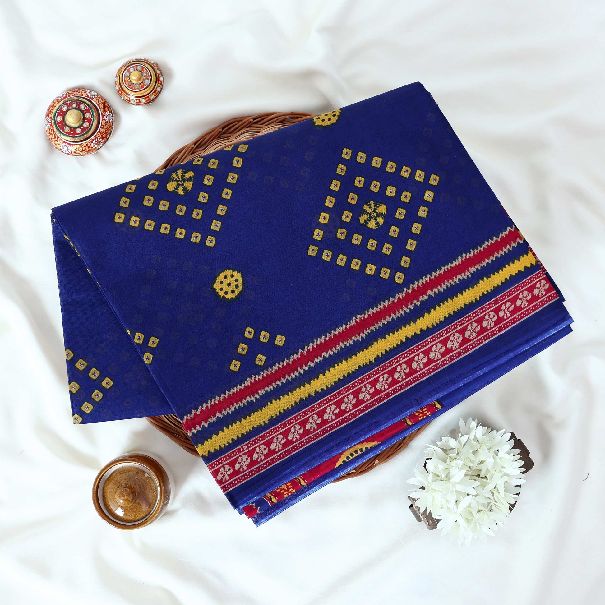 Voile cotton saree with geometric Bandhani inspired motifs and multicolor woven border in royal blue folded top view.