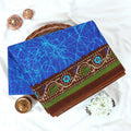 Blue Voile cotton saree with abstract crackle print body and floral contrast brown border folded top view