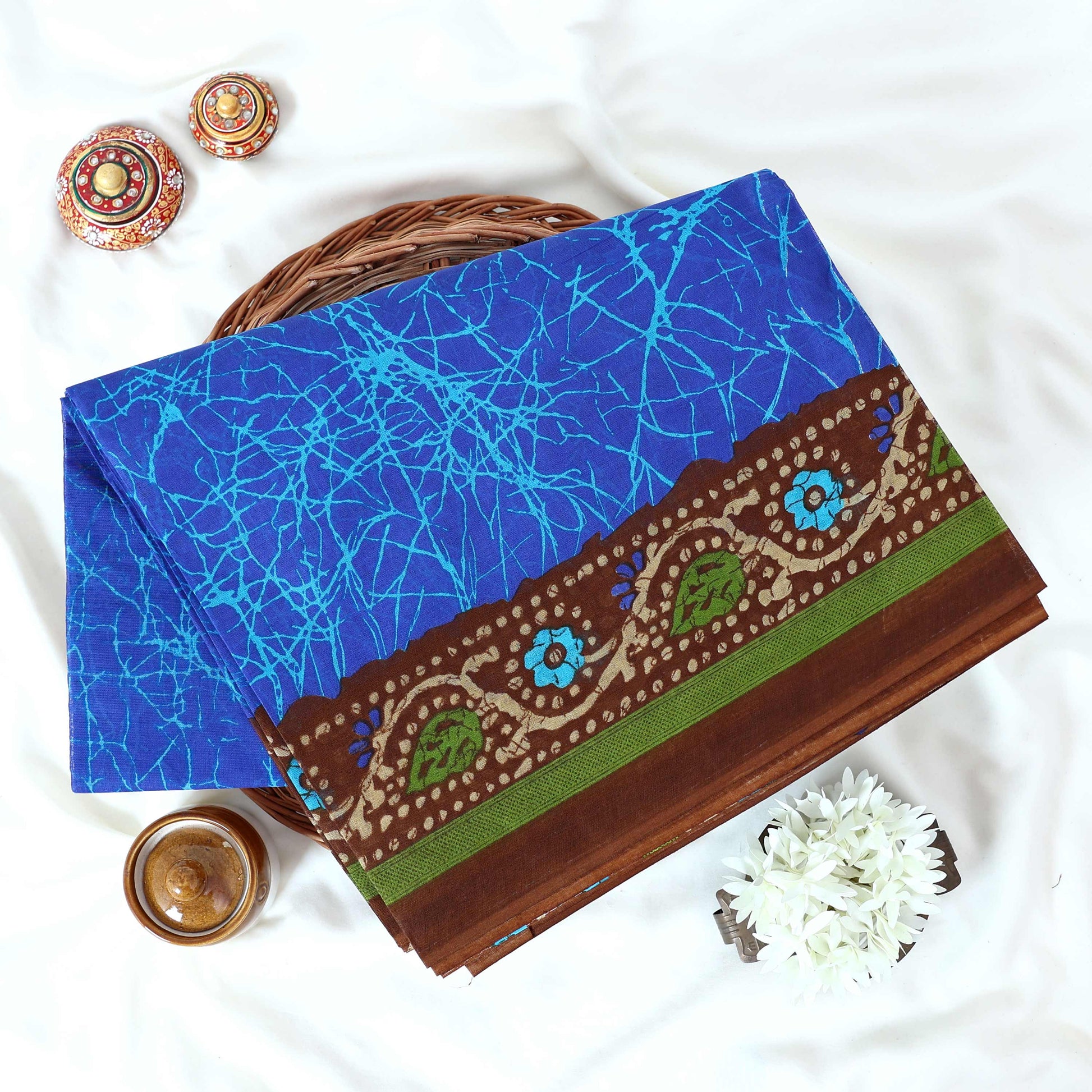 Blue Voile cotton saree with abstract crackle print body and floral contrast brown border folded top view