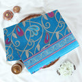 Blue Voile Cotton Saree with paisley floral print and contrast floral printed border folded top front view