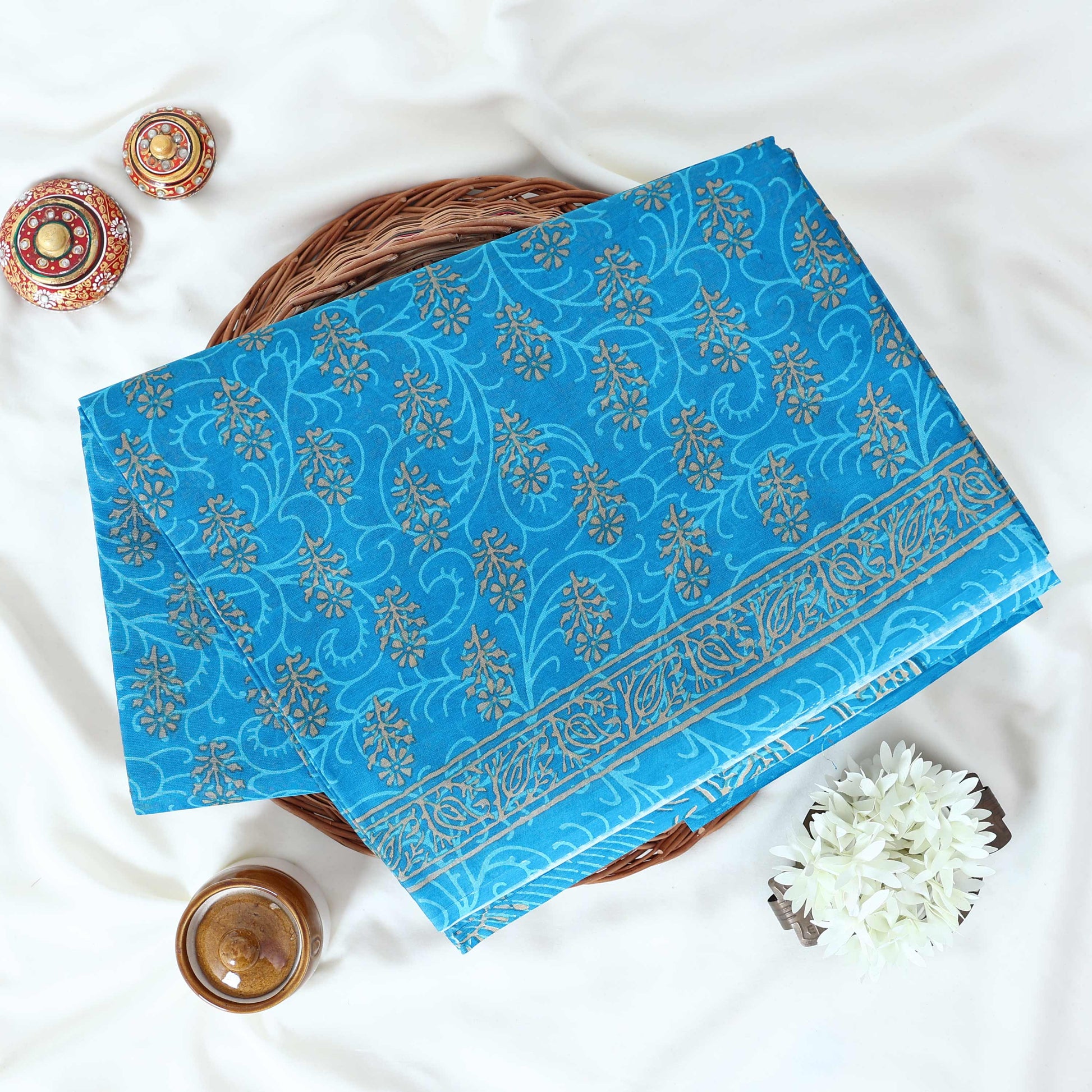 Blue Voile cotton saree with floral vine butta print and decorative border folded flat lay view