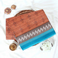 Brown voile cotton saree with ikat printed pattern and contrast chevron zari border, folded top view display