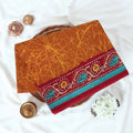 Brown Voile cotton saree with abstract crackle print body and floral contrast red border folded top view