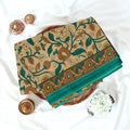Green Voile cotton saree with floral vine print and contrast border neatly folded in a top view product display.