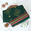 Voile cotton saree with geometric Bandhani inspired motifs and multicolor woven border in green folded top view.