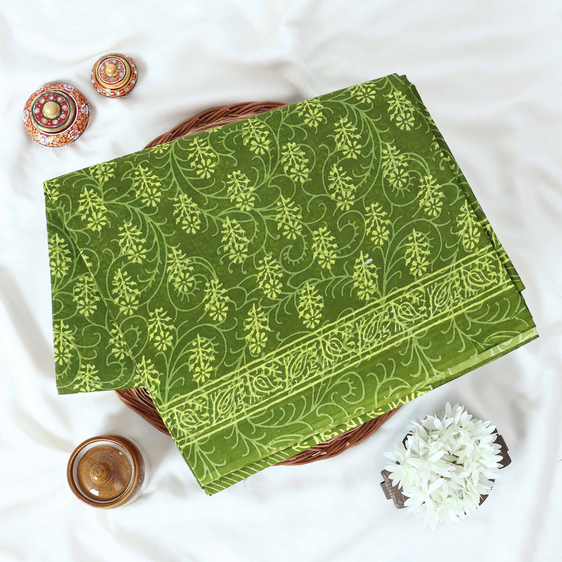Green Voile cotton saree with floral vine butta print and decorative border folded flat lay view