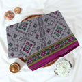 Voile cotton saree with geometric ethnic print and contrast border in grey top view folded display