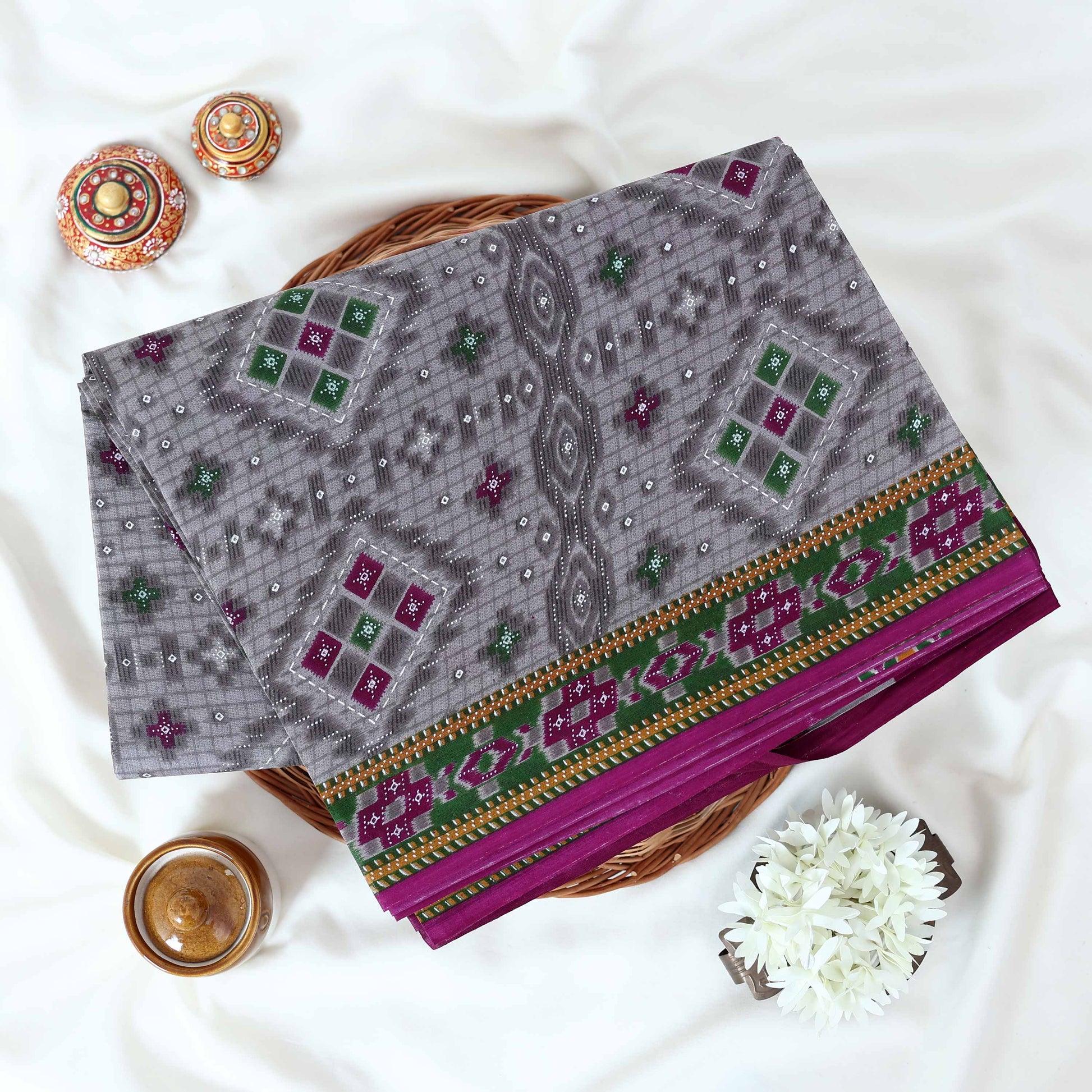 Voile cotton saree with geometric ethnic print and contrast border in grey top view folded display