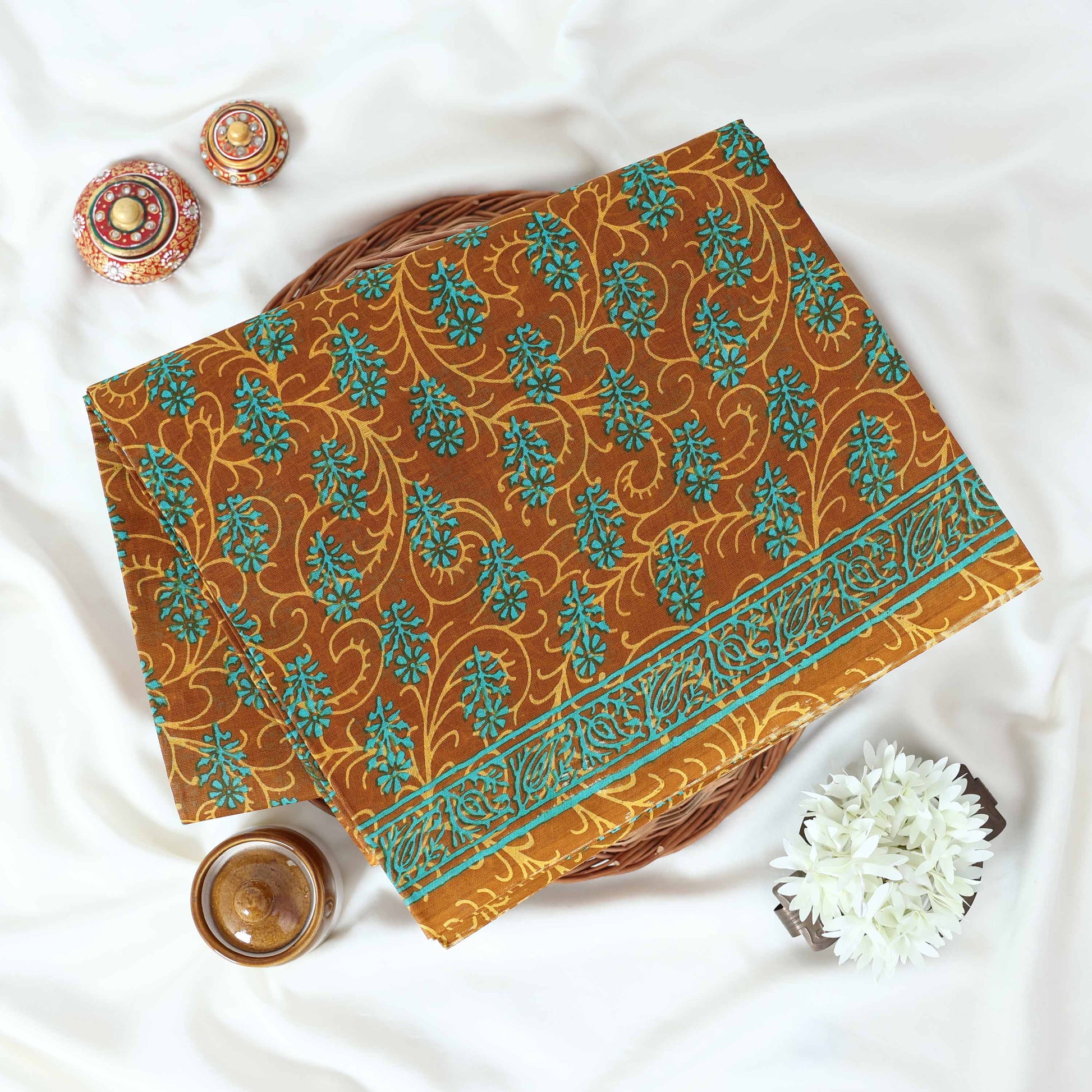 Brown Voile cotton saree with floral vine butta print and decorative border folded flat lay view