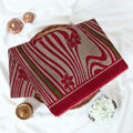 Voile cotton saree maroon floral motifs and wavy white stripe pattern with green accents top view.