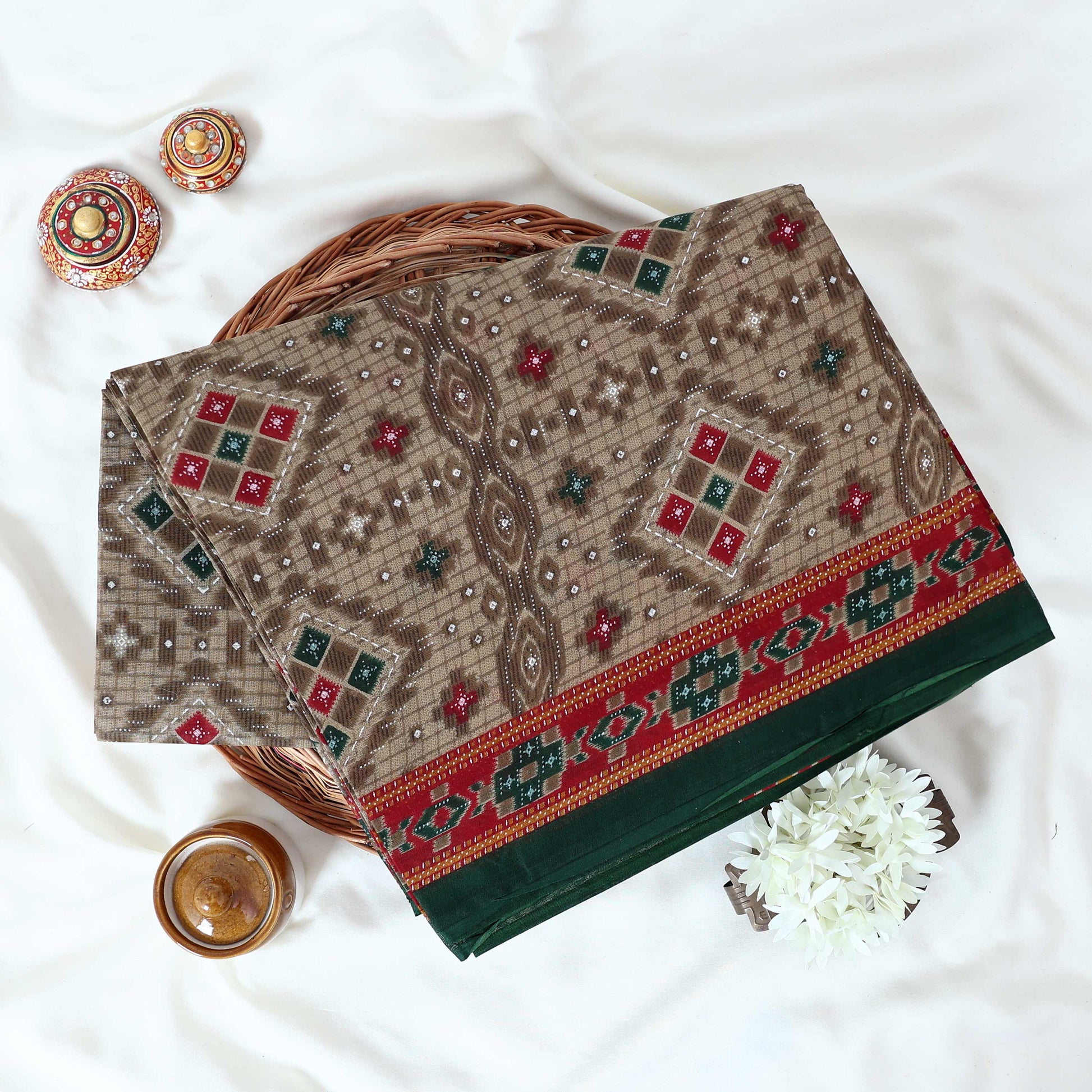 Voile cotton saree with geometric ethnic print and contrast border in olive green top view folded display