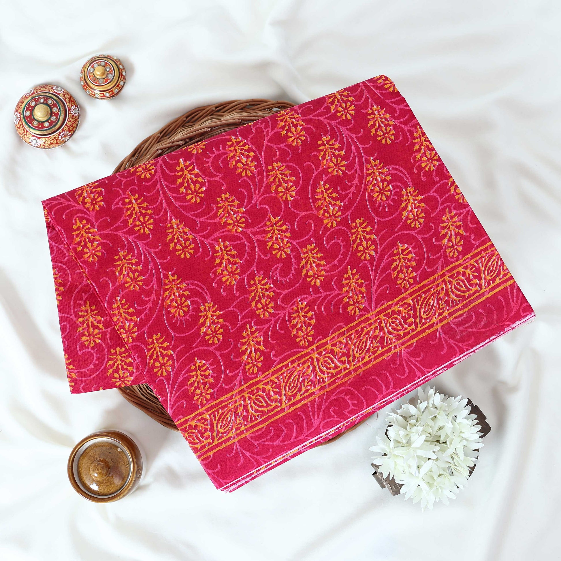 Pink Voile cotton saree with floral vine butta print and decorative border folded flat lay view
