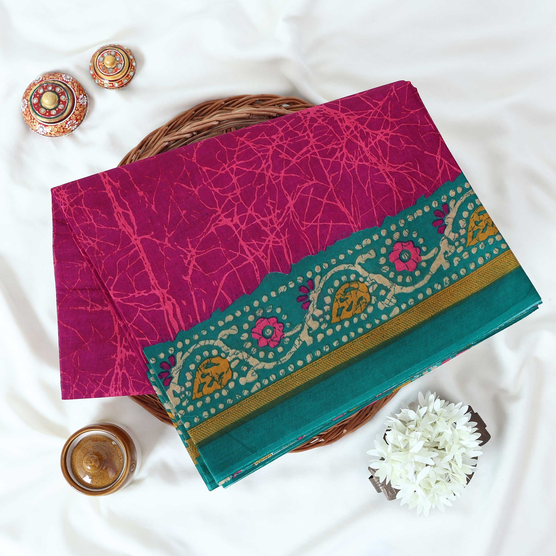 Purple Voile cotton saree with abstract crackle print body and floral contrast teal border folded top view