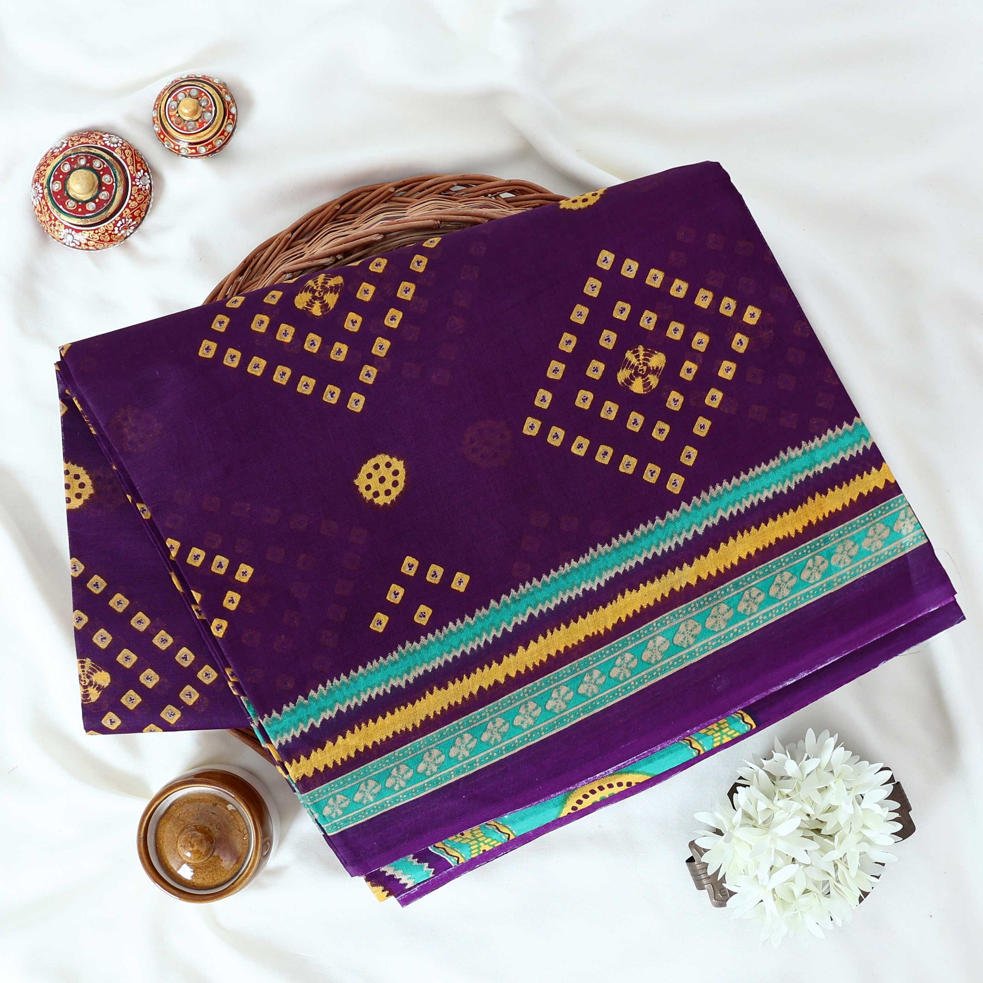 Voile cotton saree with geometric Bandhani inspired motifs and multicolor woven border in purple folded top view