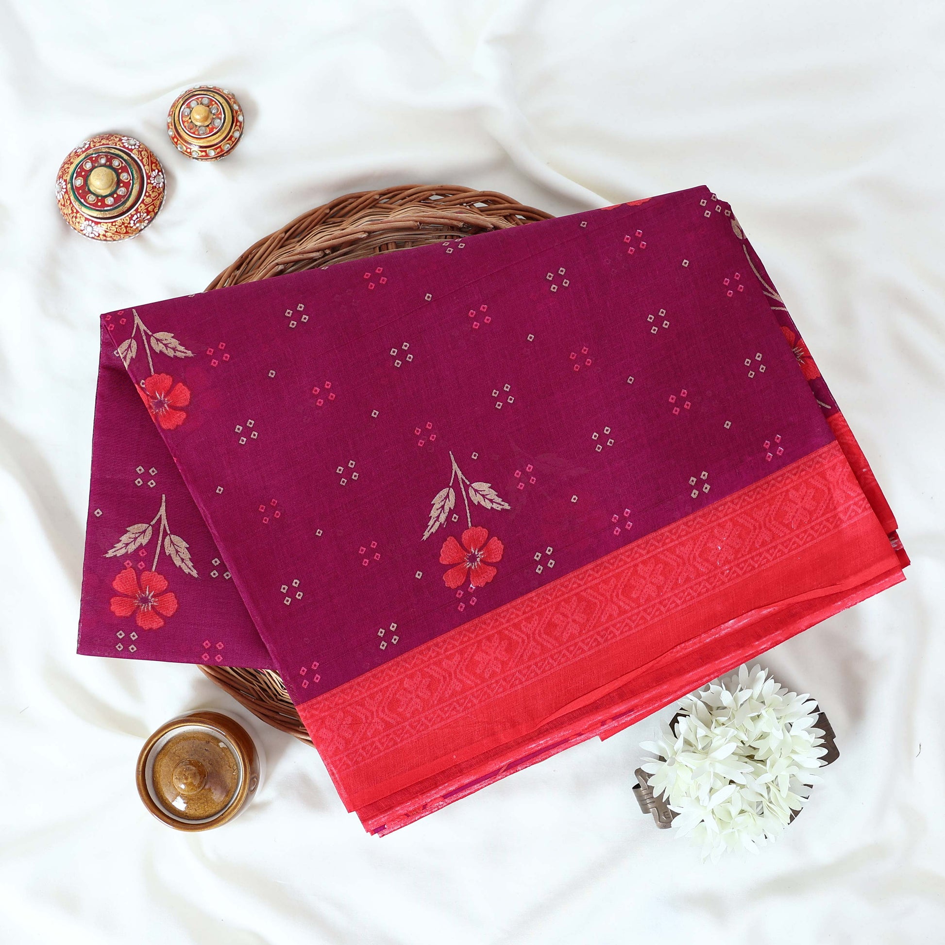 Purple Voile cotton saree with floral motifs butta body pattern and red floral motif border folded top view