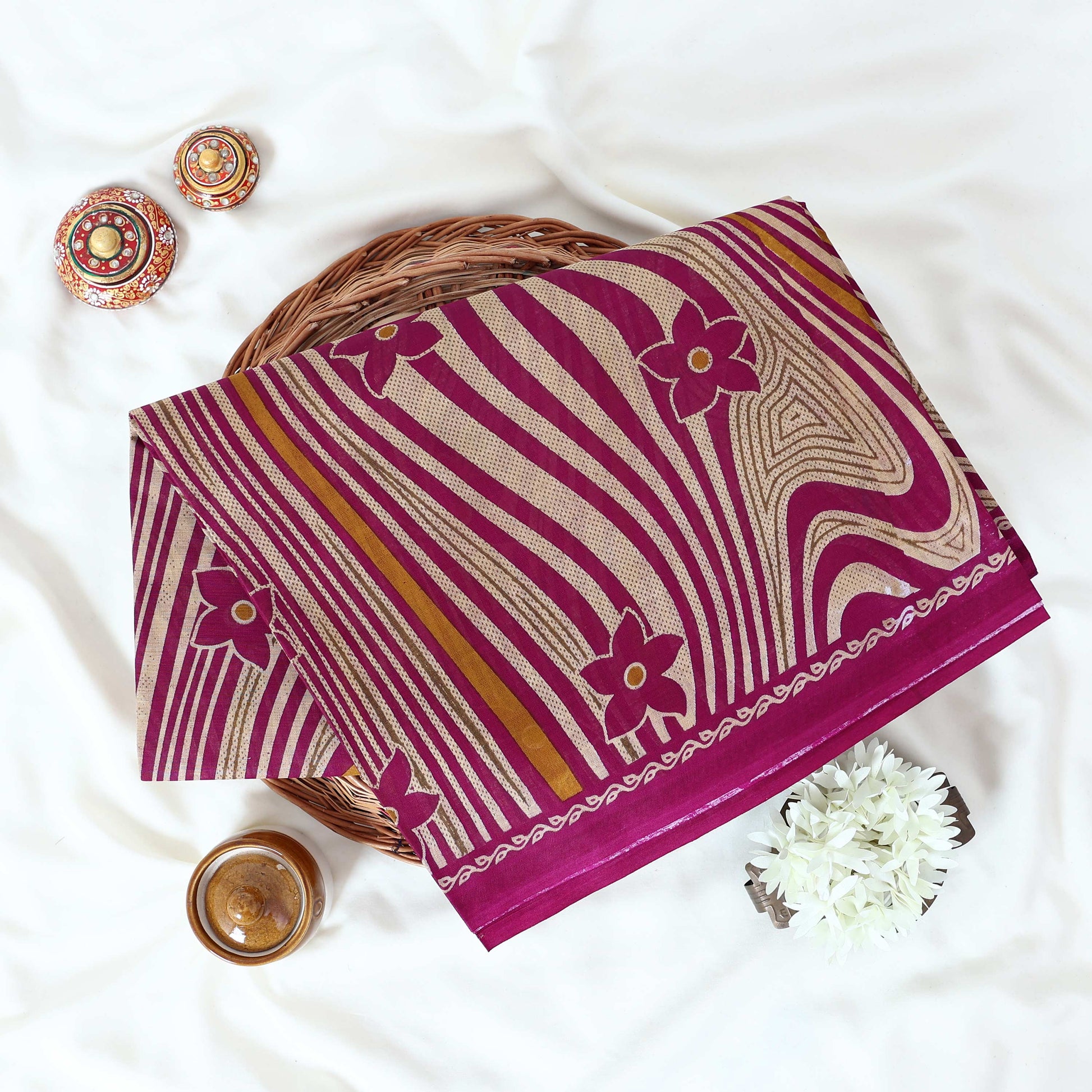 Voile cotton saree purple floral motifs and wavy beige stripe pattern with yellow accents top view.