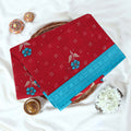 Red Voile cotton saree with floral motifs butta body pattern and blue floral motif border folded top view
