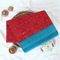 Red Voile cotton saree with spiral and floral printed motifs contrast border front flat lay view on a woven basket.