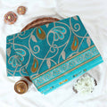 Teal Voile Cotton Saree with paisley floral print and contrast floral printed border folded top front view
