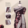 Dark Brown Dola silk saree with floral print and silver woven border front view on mannequin with detailed pallu.