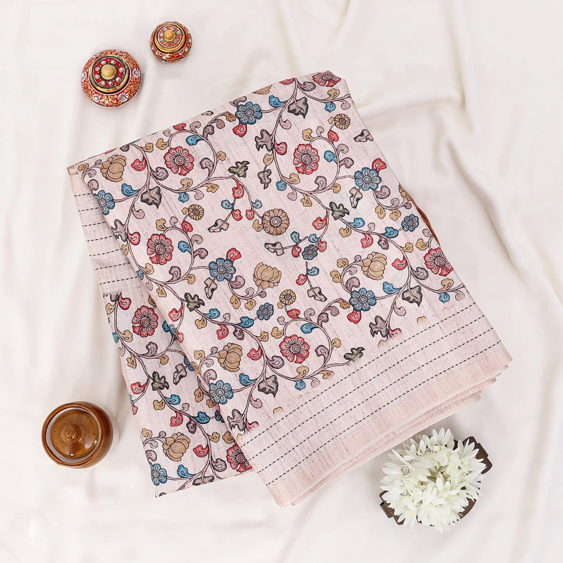 A beige and white striped saree with colorful floral prints