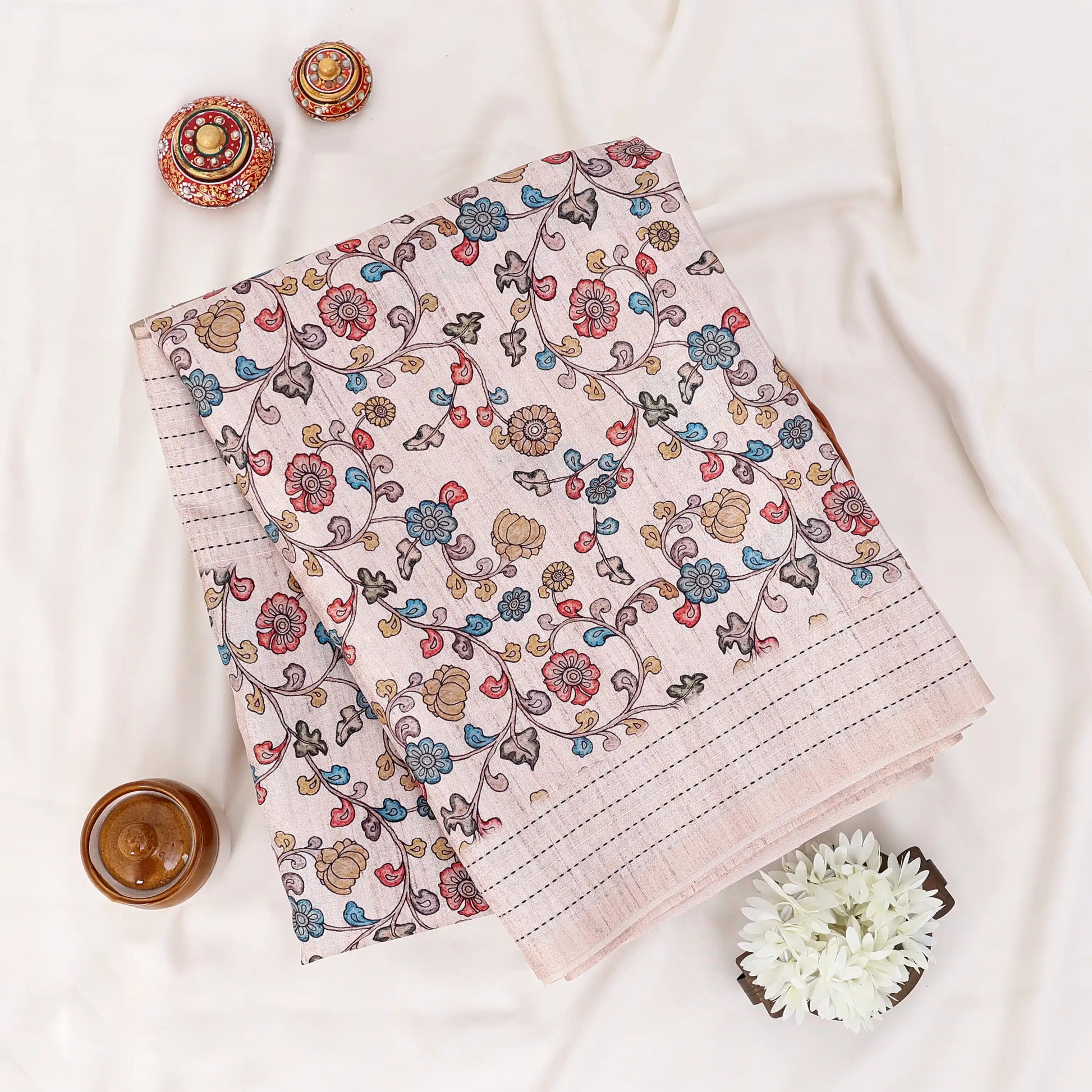 Folded A beige and white striped saree with colorful floral prints