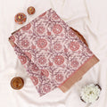 A folded patterned fabric piece with a floral block print in dusty pink, mauve, and terracotta tones
