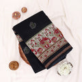 A black cotton saree with intricate multicolor floral and geometric borders